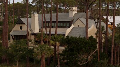 a vast home with stone architecture and chimneys surrounded by trees on Kiawah Island