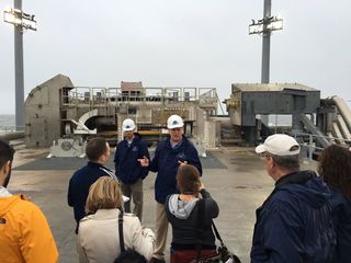 Dale Nash, executive director of the Virginia Commercial Spaceflight Authority, (center), gives members of the press a tour of the Mid-Atlantic Regional Spaceport Pad-0A at NASA's Wallops Flight Facility in Virginia on Dec. 17, 2015. The launchpad has been repaired after an October 2014 rocket explosion.