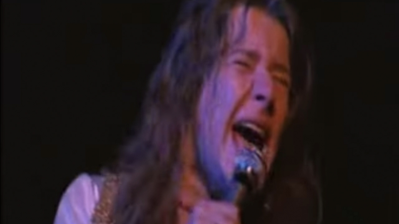 Close up of Janis Joplin singing intensely with a microphone