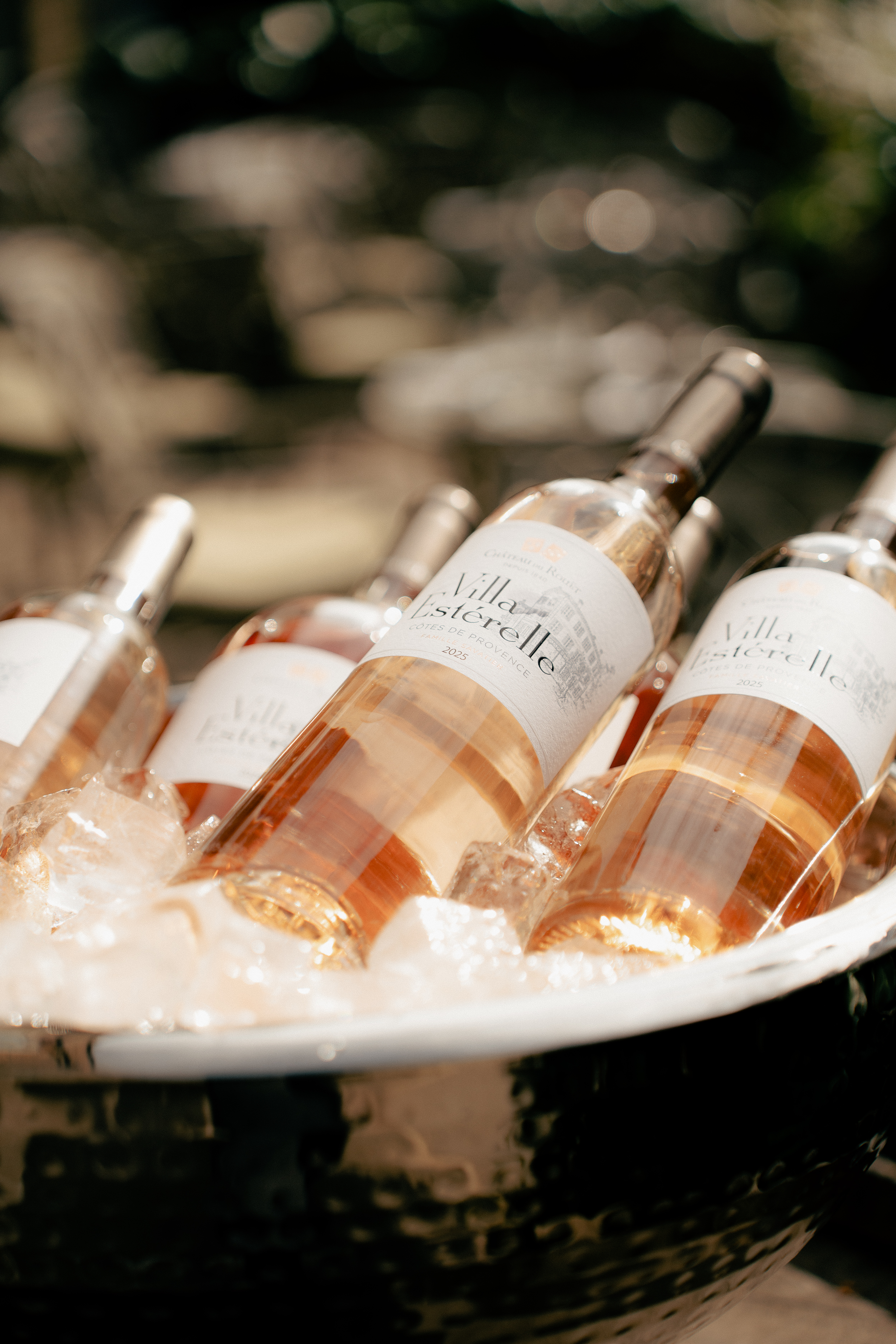 an image of bottles of rose stacked in an ice bucket on a sunny day