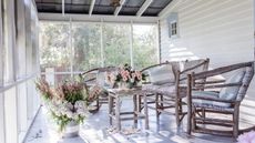 White porch with vintage furniture and country flowers