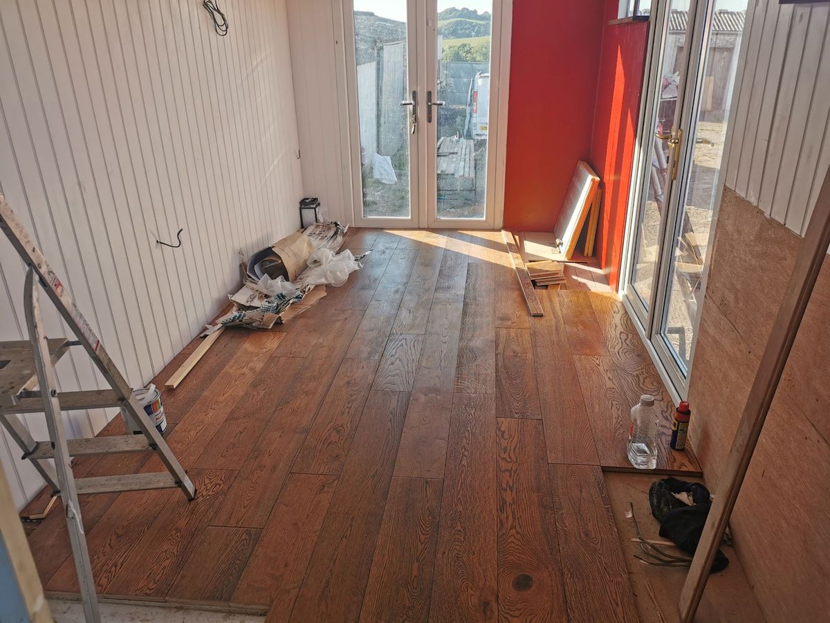 The indoor flooring and walls installed with wooden panels and the walls are painted white
