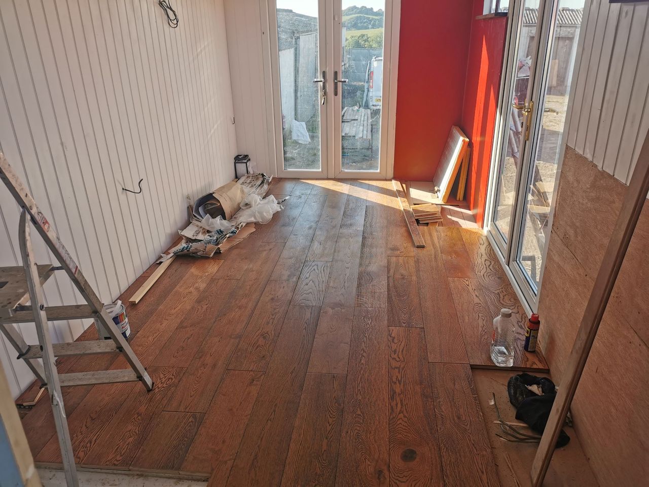 The indoor flooring and walls installed with wooden panels and the walls are painted white