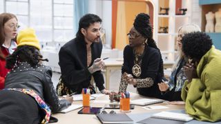A stylishly attired group of new contestants lean in as they discuss their fashion-forward designs for a "Project Runway" challenge in "Project Runway" season 21.