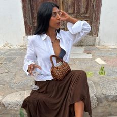 Monikh wearing white shirt and brown skirt