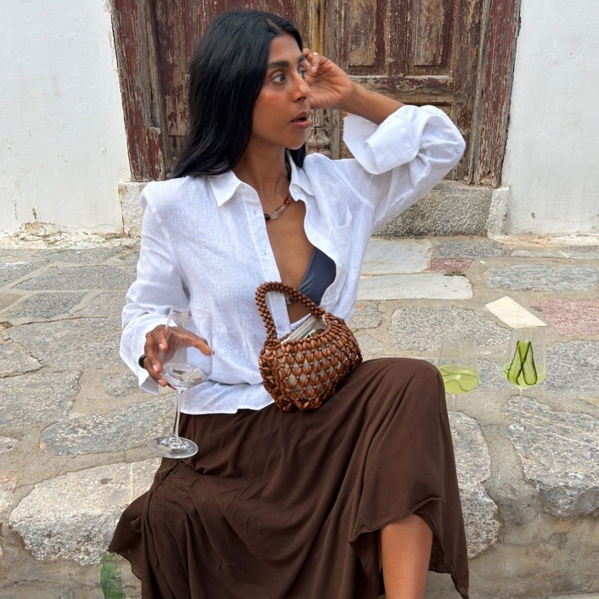 Monikh wearing white shirt and brown skirt