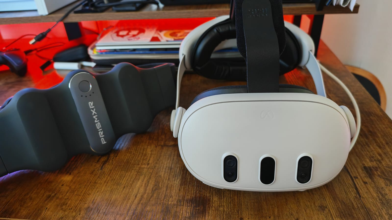 A Meta Quest 3S sitting next to the PrismXR Carina charging belt