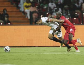 Egypt’s Trezeguet, left, and Jefferson Encada of Guinea-Bissau fight for the ball