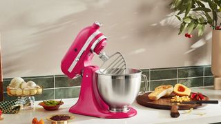 A KitchenAid artisan stand mixer in hibiscus, KitchenAid color of the year 2023