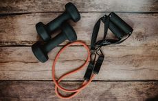 Small dumbbells and a skipping rope on a wooden table