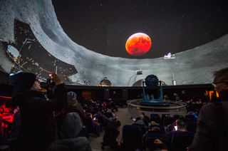 In a planetarium, the livestream of the total lunar eclipse of the blood wolf moon from the Griffith Observatory in Los Angeles was superimposed onto a 360-degree panorama photo of the Chinese space vehicle "Jadehase," on Jan. 21, 2019.