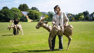 A woman controls a large, lifelike puppet antelope for The Herds project