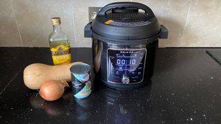 The Instant Pot Pro Plus Smart Multi-Cooker and some ingredients on a kitchen counter