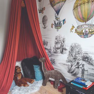 A children's playroom with hot air balloon wallpaper and a reading nook