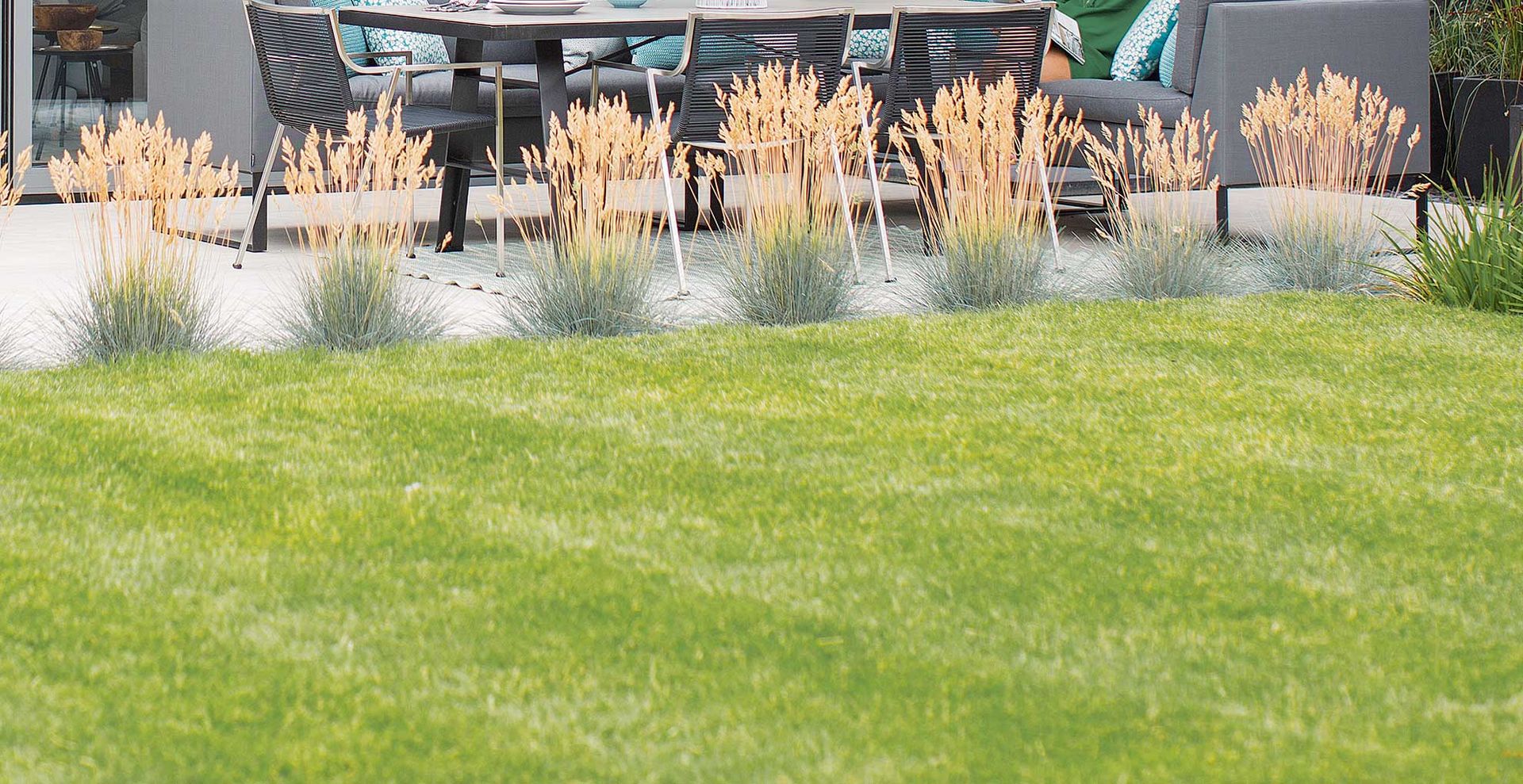 striped lawn with grass border to support mowing direction as an essential summer lawn care tip