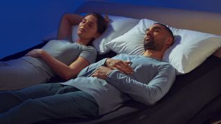 Two people sleep comfortably on a bed fitted with the Eight Sleep Pod 4 Ultra smart cooling mattress cover and adjustable base system