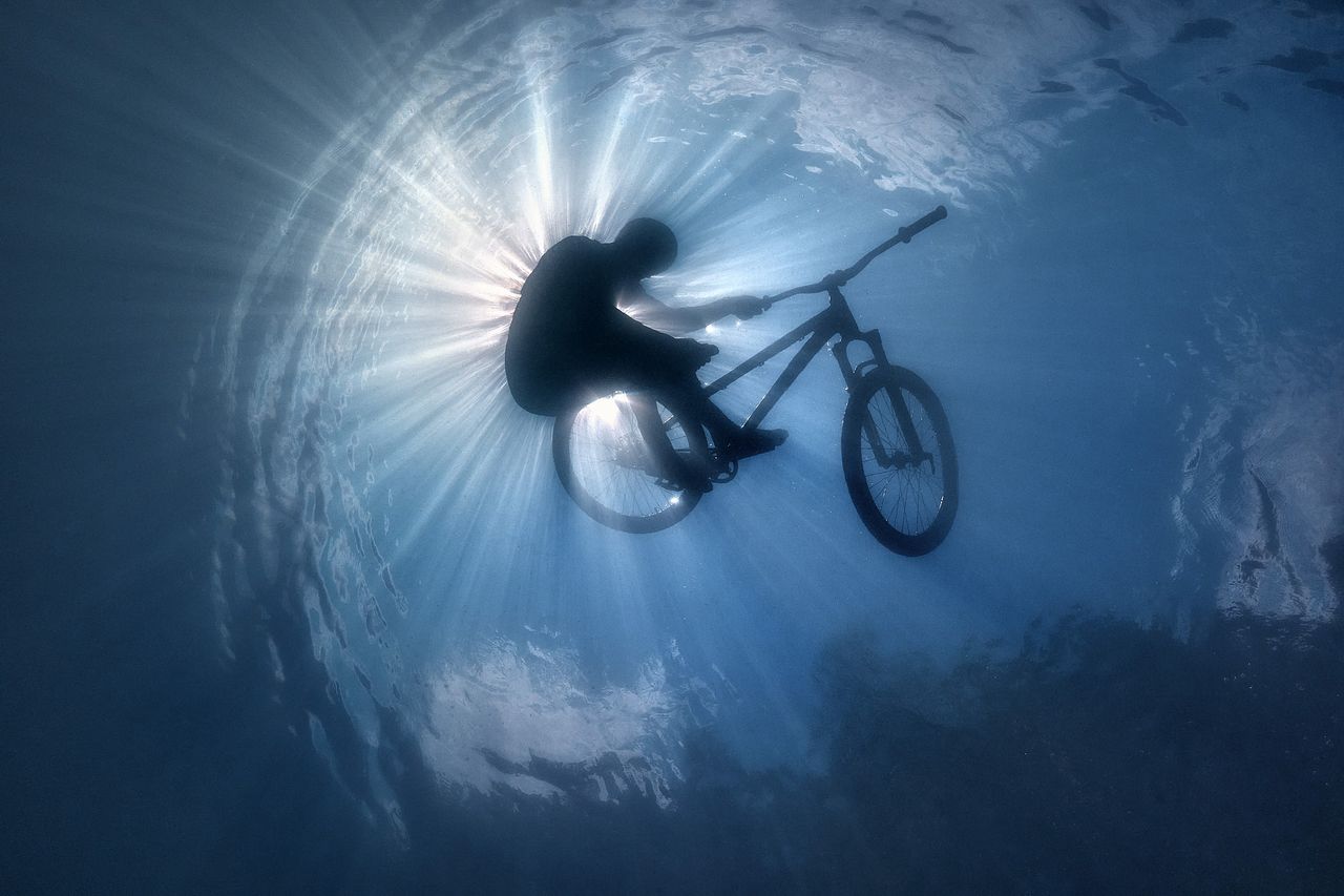 A photograph by Volodya Voronin of a BMX rider submerged in water