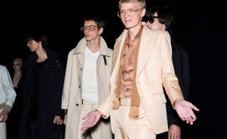 Models wear trench and crew, suit with satin shirt at Tom Ford S/S 2019