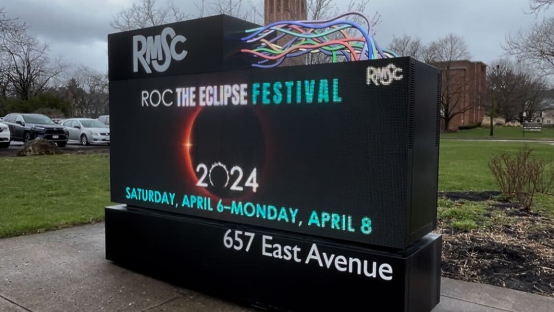 Rochester sign illuminated shows the ROC the eclipse festival graphic.