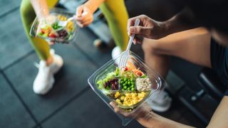 two people eating food at the gym