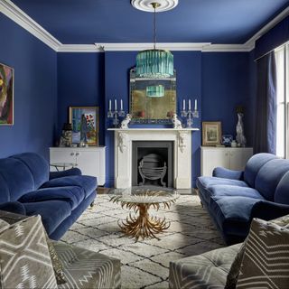 living room with wooden flooring and blue wall and blue sofa set