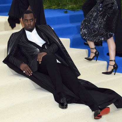 Diddy lays on a carpeted staircase posing for the press.