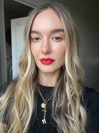 beauty director Hannah Baxter wears a red celine lipstick in her apartment