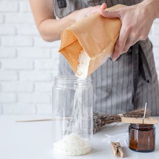 Woman making decorative aroma candle at table