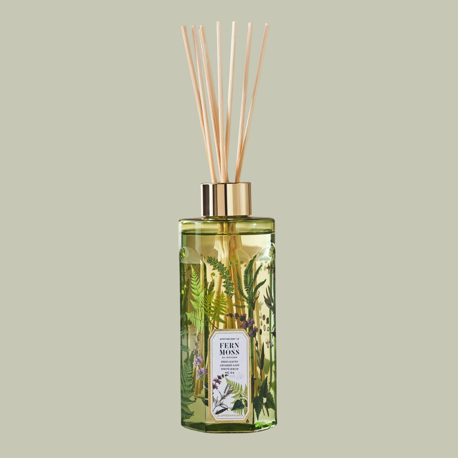 A patterned green glass reed diffuser against a light green backdrop