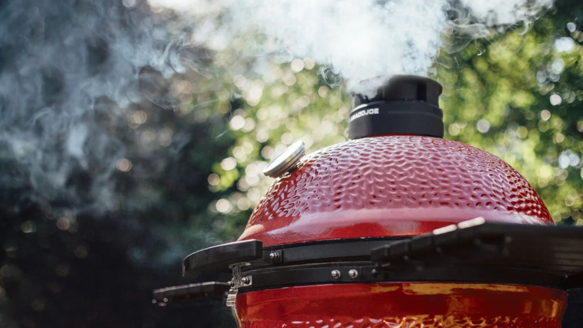 kamado joe grill with smoke coming out of the top