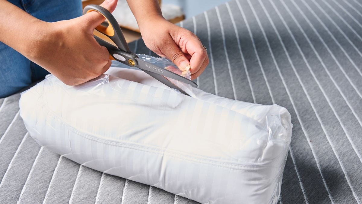 Cutting through the thin plastic film packaging of the pillow