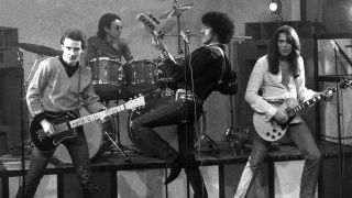 A photograph of Thin Lizzy with Midge Ure on guitar in 1979