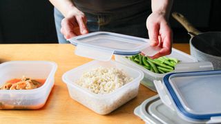 Woman putting leftovers into storage containers