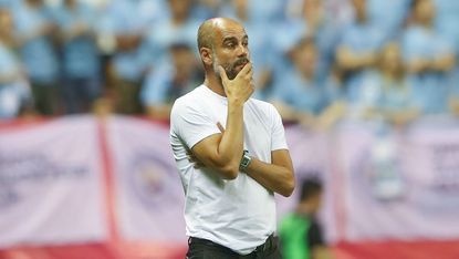 Man City head coach Pep Guardiola watches his side in action against Wolves in Shanghai 