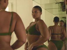 A model wearing CUUP lingerie stands in front of the mirror