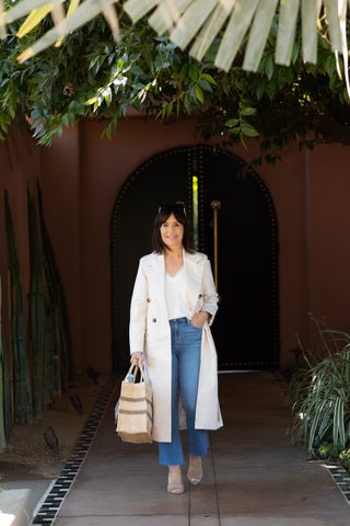 Susie Wright wears a white trench coat and jeans.