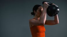 Woman holding kettlebell to do windmill exercise