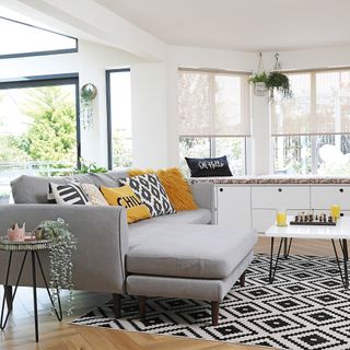 corner sofa and window seat with storage in open plan kitchen with black and white rug kitchen