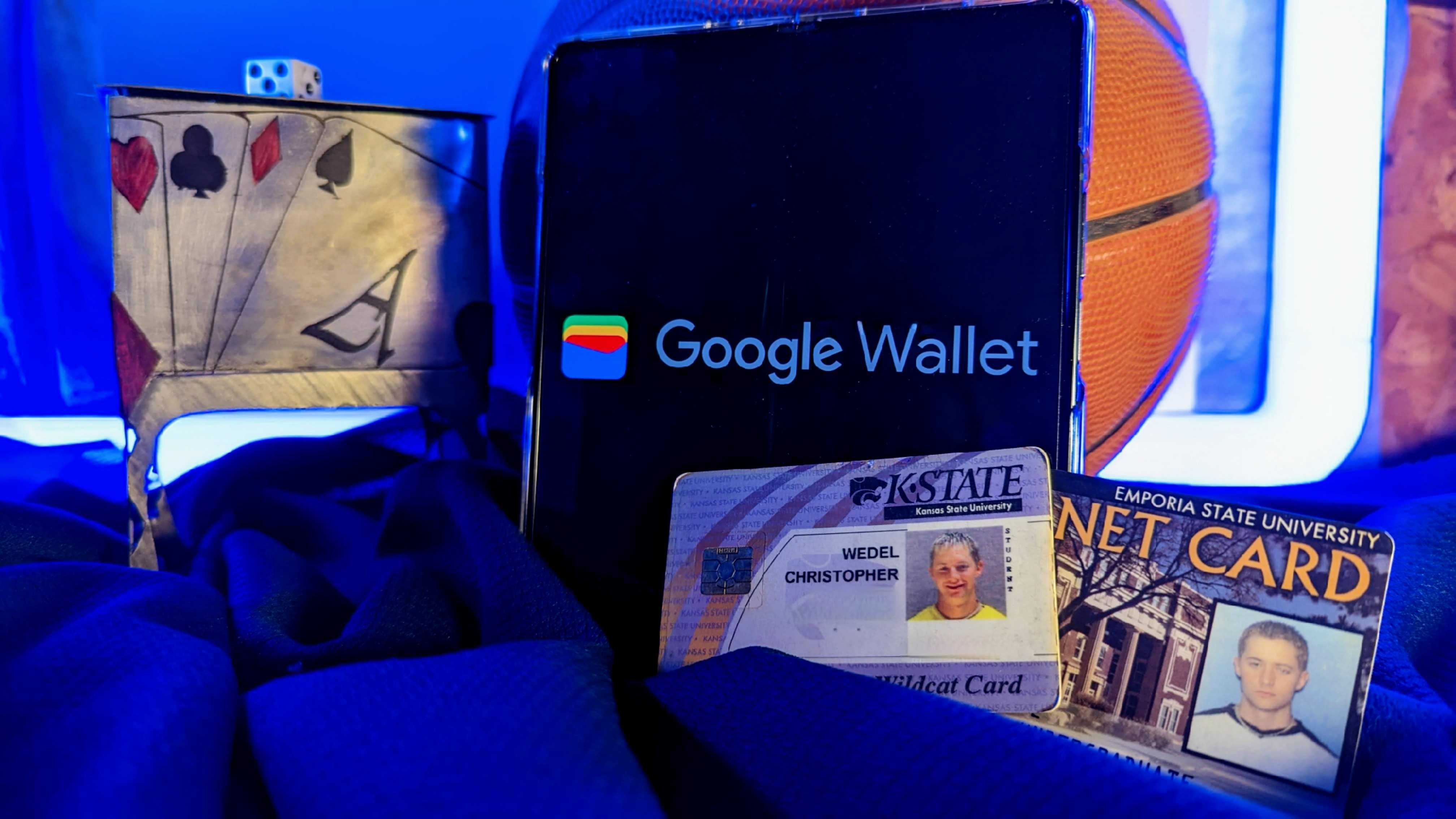 College IDs sitting next to an Android phone with the Google Wallet app logo