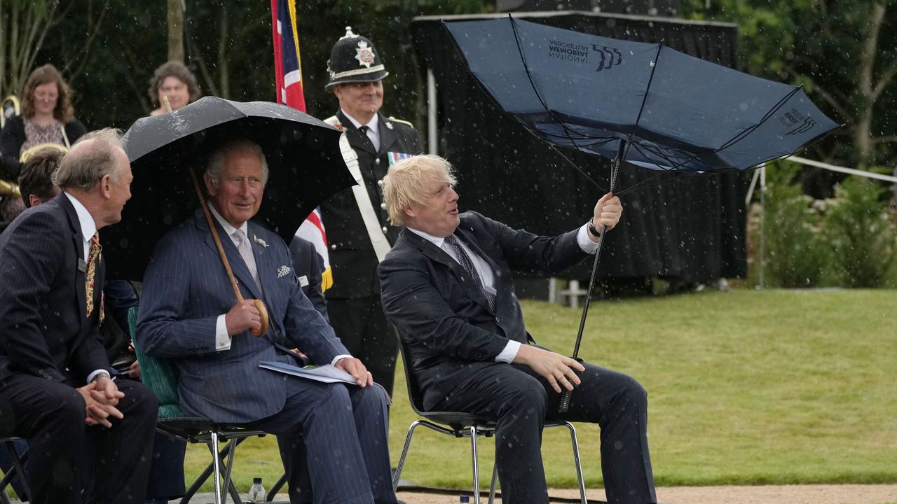 stafford, england july 28 prince charles, prince of wales looks on as c british prime minister, boris johnson r opens his umbrella at the national memorial arboretum on july 28, 2021 in stafford, england the police memorial, designed by walter jack, commemorates the courage and sacrifice of members of the uk police service who have dedicated their lives to protecting the public the memorial is set on grounds landscaped by charlotte rathbone within the national memorial arboretum and stands along with 350 memorials for the armed forces, civilian organisations and voluntary bodies who have played their part serving the country photo by christopher furlong wpa poolgetty images