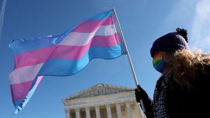 A transgender rights activist stands outside the United States Supreme Court building on Dec. 4, 2024.