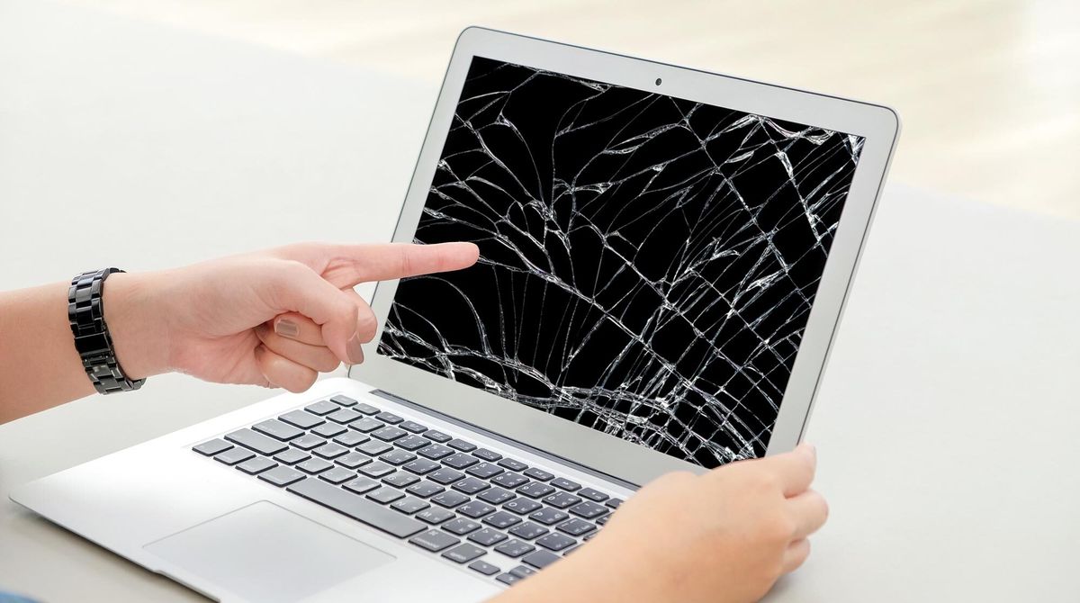 A broken MacBook with a shattered screen