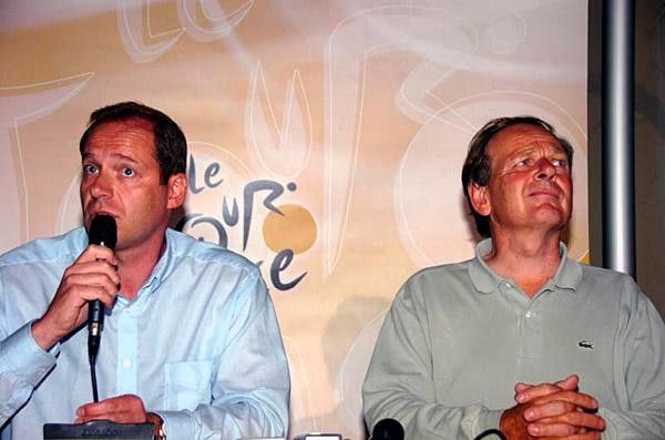 Christian Prudhomme speaks while Patrice Clerc looks on, pained by recent doping news.