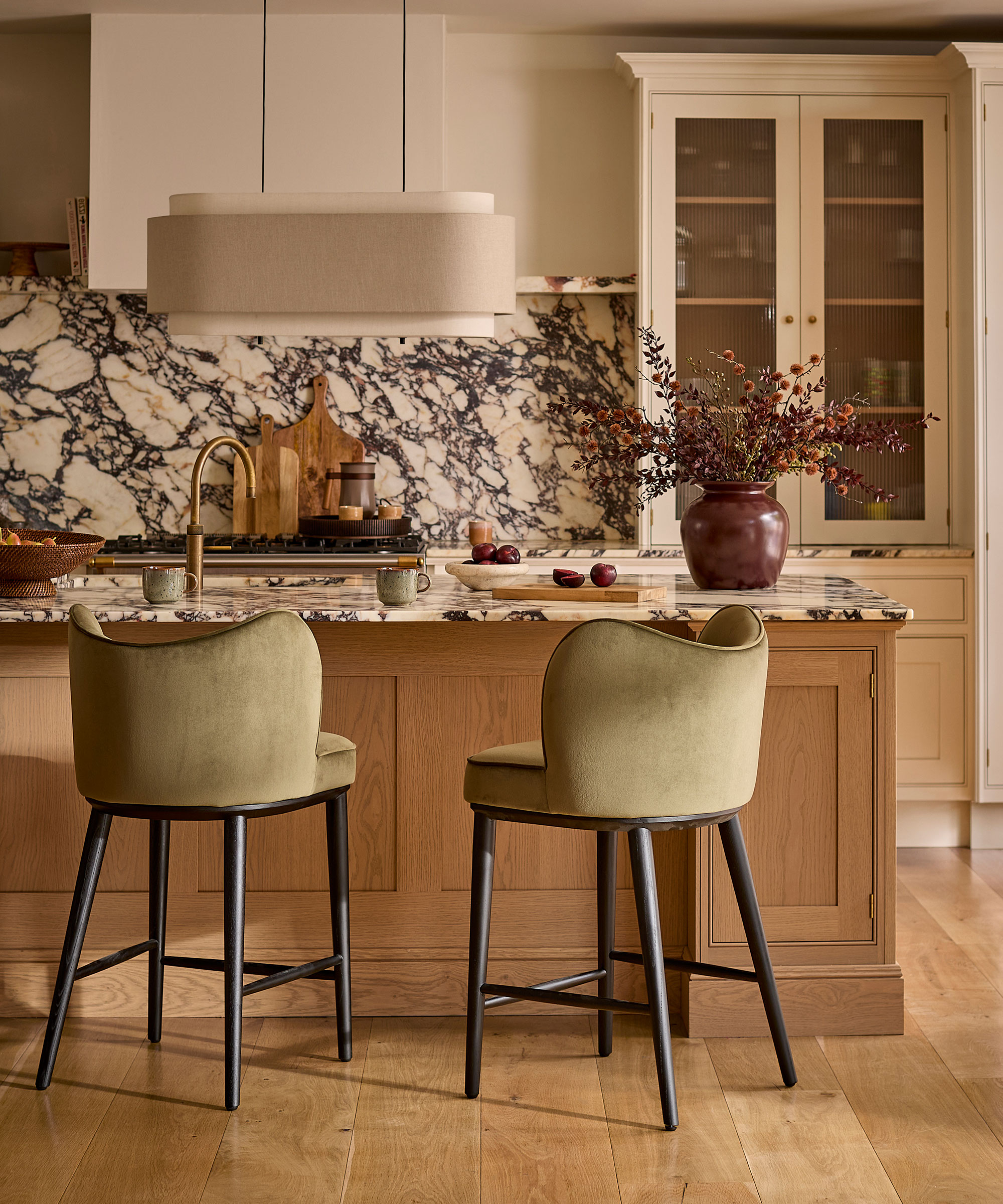 wooden kitchen with marble splashback and oversized island lighting