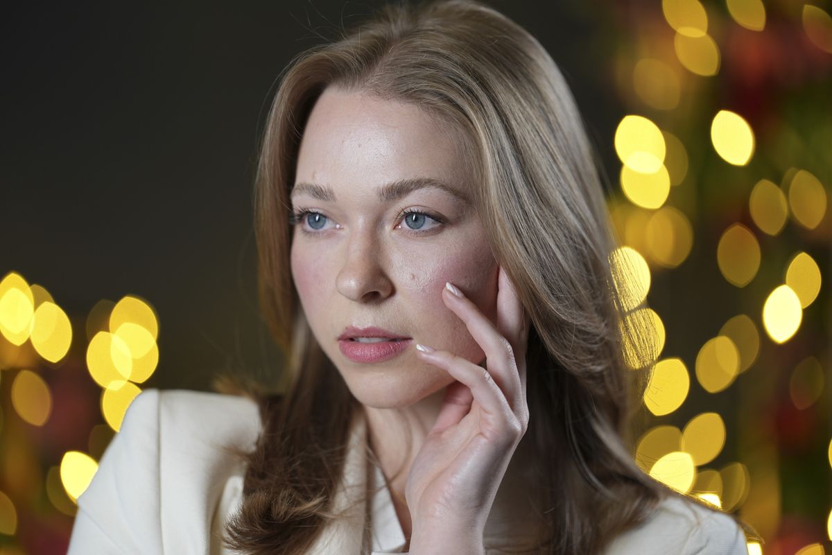 Portraits of a woman in smart jacket, in a studio with blurred fairy lights in background