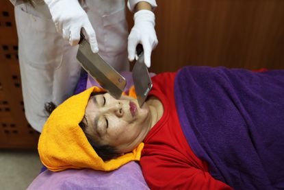 Angelina Hsiao (unseen), a knife therapy practitioner, conducts knife therapy massage on a woman at the Ancient Art of Knife Therapy Education Center in Taipei, Taiwan, 17 April 2018.