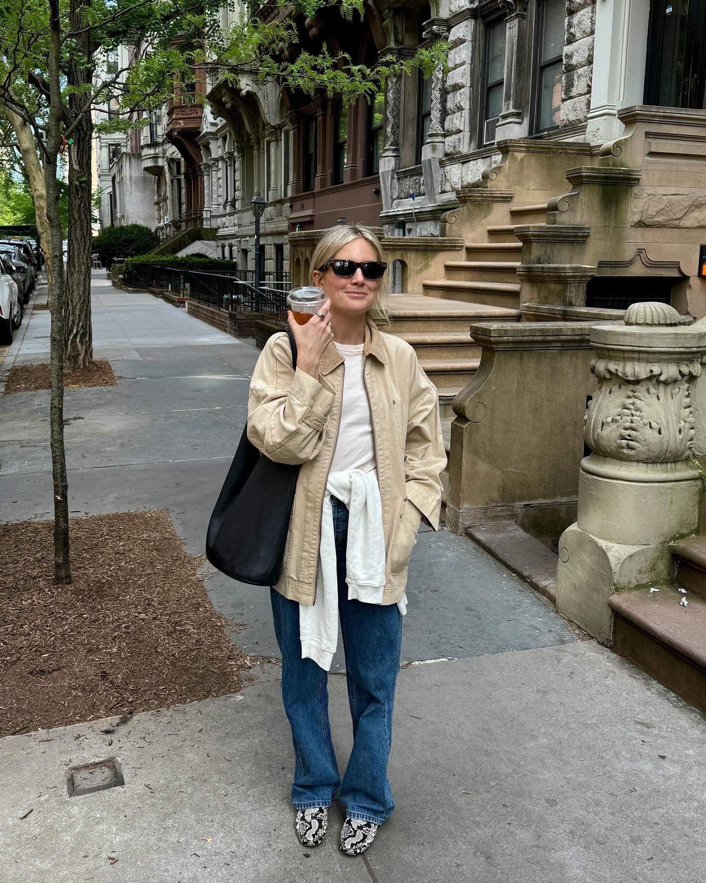 Influential man @lucywilliams02 wearing blue jeans with snake print bread, white t-shirt, beige barn jacket and black tote bag. She stood on the streets of New York.