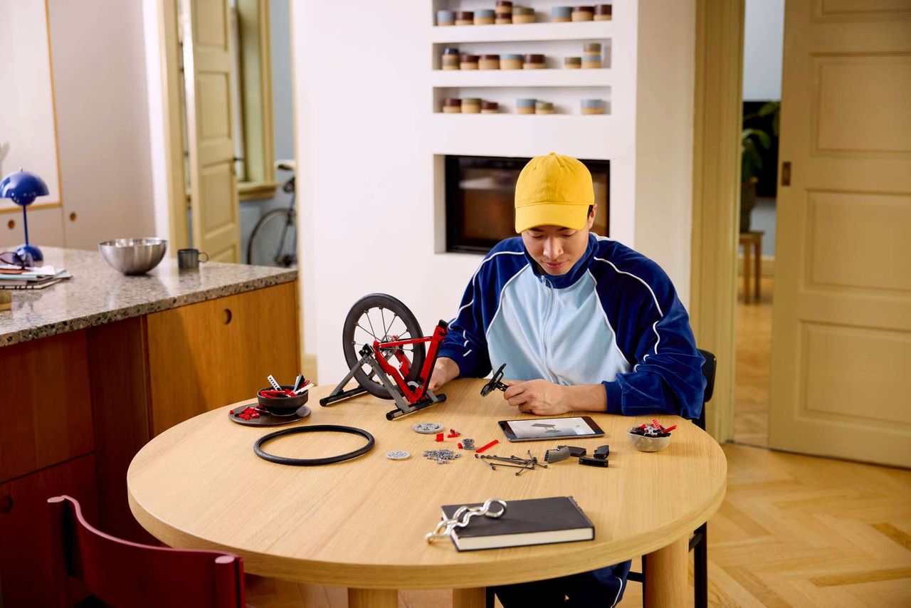 Man sat at table building the The Lego Icons Road Bike set