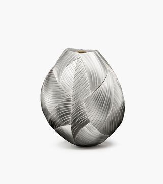 A metallic silver coloured vase split into multiple segments. A wider centre that narrows at the top and the bottom.