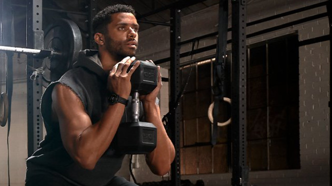 Man working out with weights wearing Garmin Epix watch